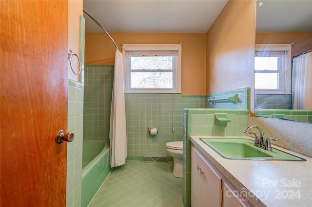 full bathroom featuring tile patterned flooring, vanity, a wealth of natural light, and tile walls