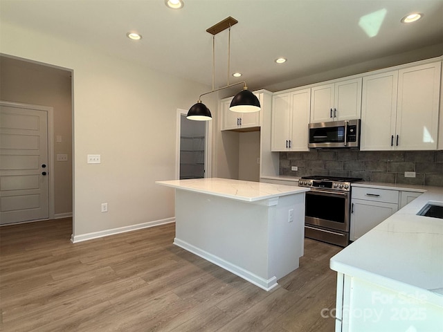 kitchen featuring stainless steel appliances, backsplash, and white cabinetry