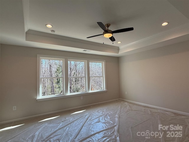 empty room with a tray ceiling, visible vents, baseboards, and recessed lighting