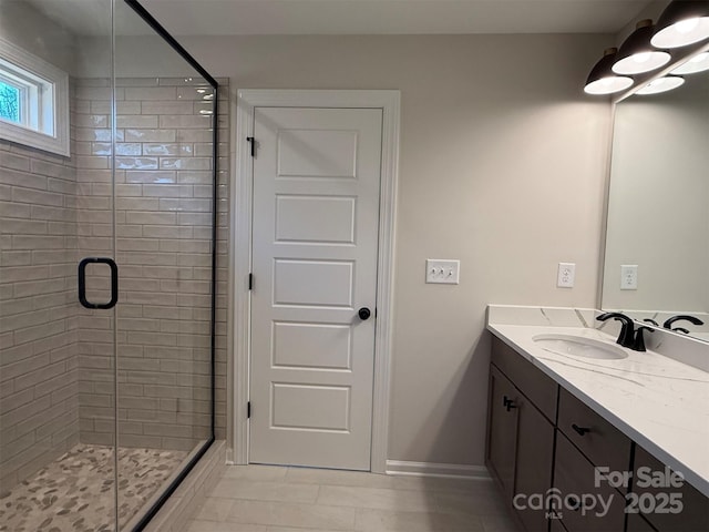 bathroom with a shower stall, baseboards, and vanity