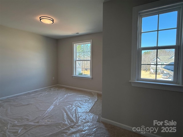 unfurnished room with visible vents and baseboards