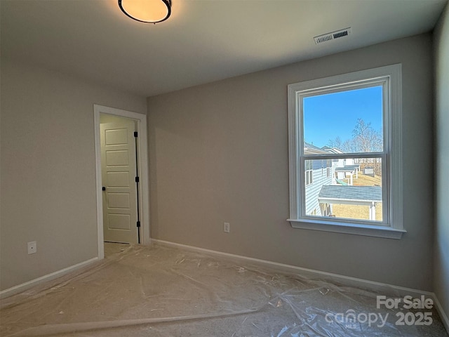 spare room featuring visible vents and baseboards