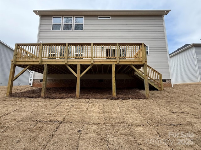 back of property featuring stairs and a wooden deck