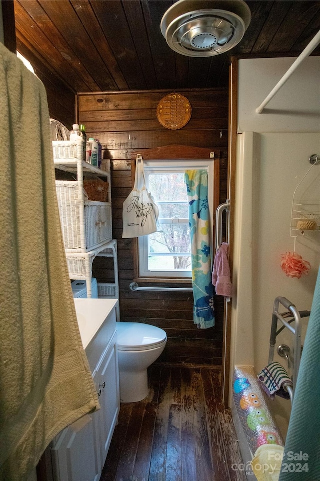 bathroom featuring wood-type flooring, toilet, wood walls, wooden ceiling, and vanity