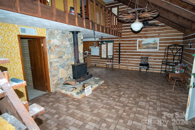 unfurnished living room with lofted ceiling and a wood stove