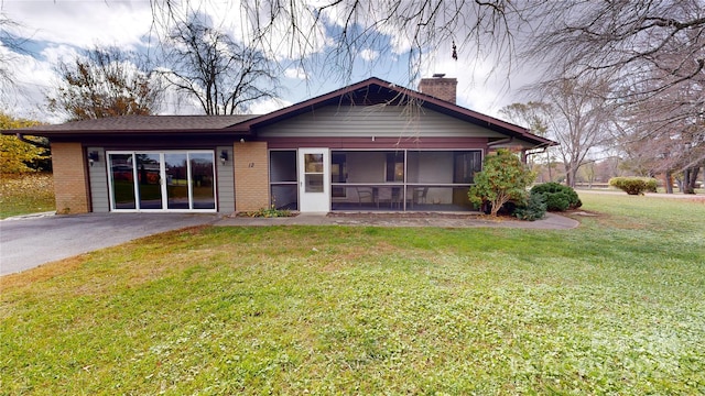 12 Moland Dr, Etowah, NC 28729 - back of house featuring a chimney, brick siding, a yard, and a sunroom