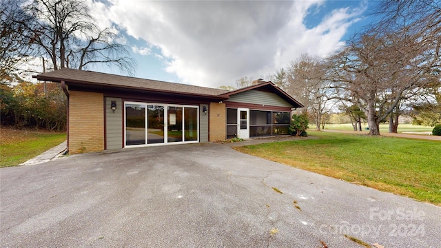 view of front of property featuring a front lawn and a sunroom