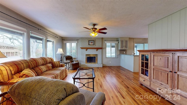 living room featuring light wood-type flooring, wooden walls, and a healthy amount of sunlight