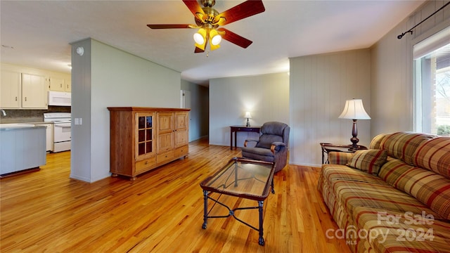 living room with light hardwood / wood-style floors, ceiling fan, and sink