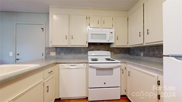 kitchen with white appliances, white cabinetry, backsplash, and hardwood / wood-style flooring