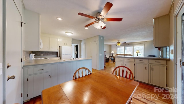 dining room with ceiling fan, a textured ceiling, and light hardwood / wood-style floors