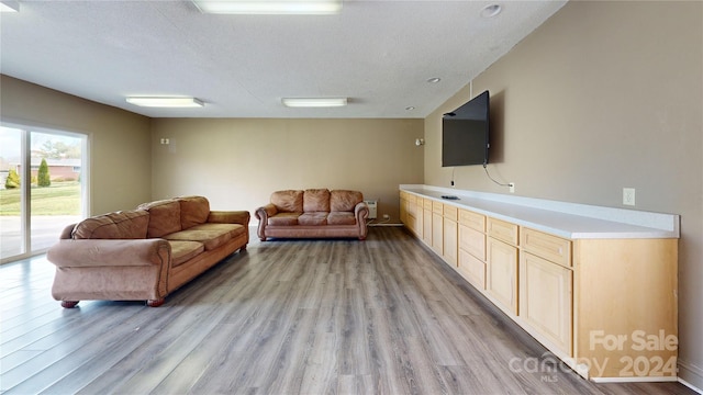 living room featuring light wood-type flooring and a textured ceiling