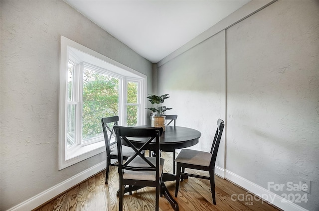 dining area with lofted ceiling and hardwood / wood-style flooring