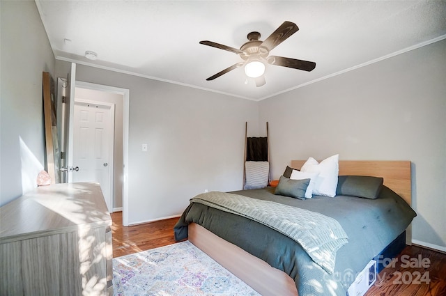 bedroom featuring dark wood-type flooring, ceiling fan, and ornamental molding