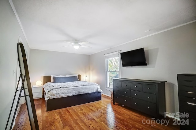 bedroom with ornamental molding, hardwood / wood-style flooring, and ceiling fan