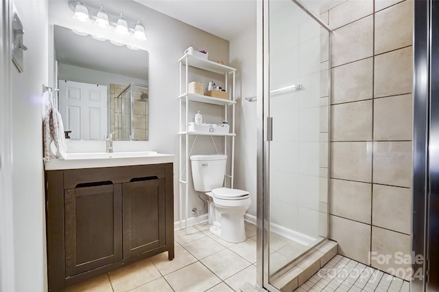 bathroom with toilet, an enclosed shower, vanity, and tile patterned flooring