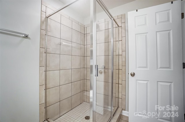 bathroom with an enclosed shower and tile patterned floors