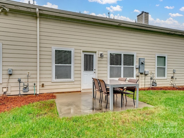 rear view of property featuring a patio area and a lawn