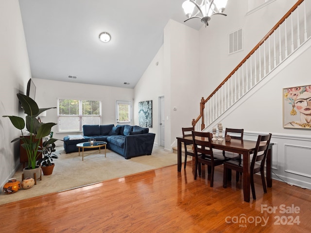 dining space with light hardwood / wood-style flooring and high vaulted ceiling