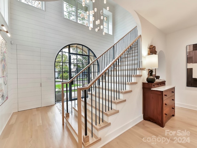 stairway featuring hardwood / wood-style floors and a high ceiling