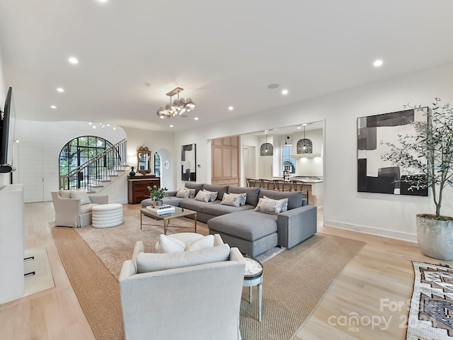 living room with light wood-type flooring and a notable chandelier