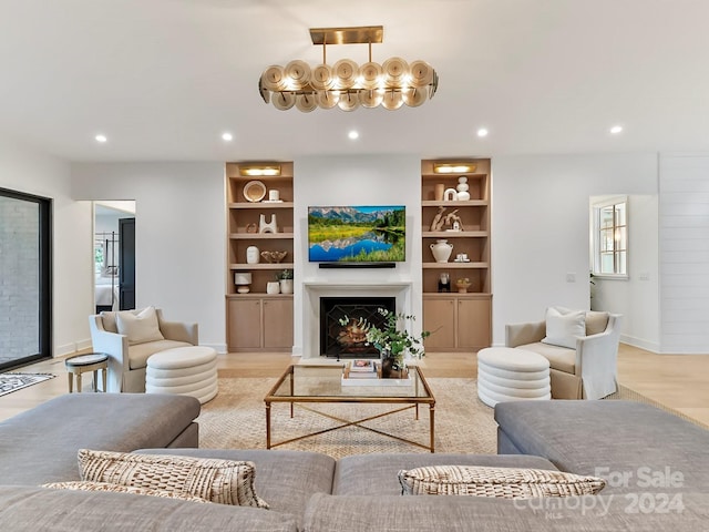 living room featuring built in features and light hardwood / wood-style flooring