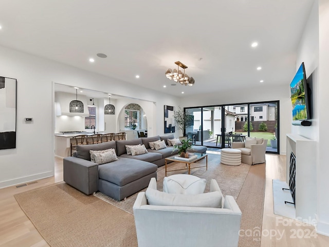 living room featuring an inviting chandelier and light hardwood / wood-style flooring