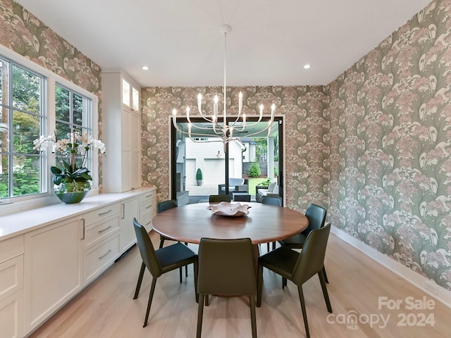 dining room featuring light wood-type flooring and a chandelier