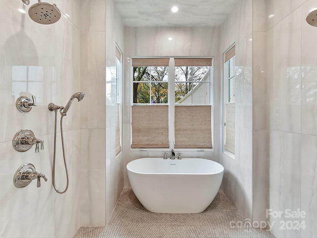 bathroom with tile patterned flooring, shower with separate bathtub, and tile walls