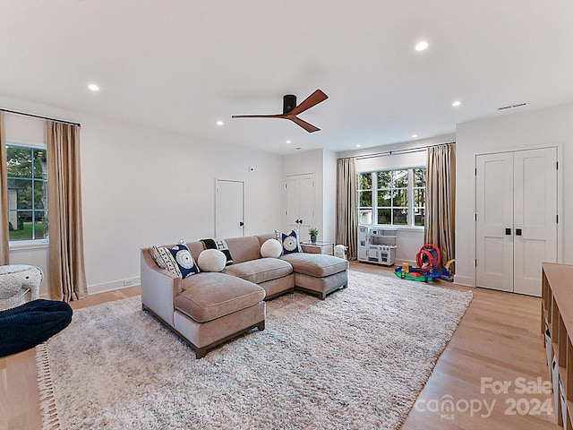 living room with light hardwood / wood-style floors and ceiling fan