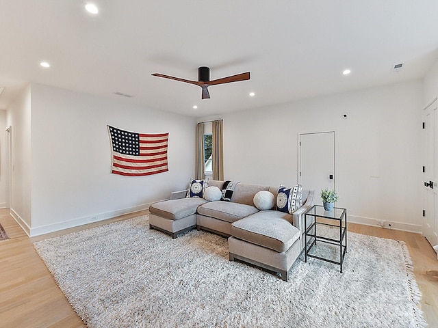 living room featuring light hardwood / wood-style floors and ceiling fan