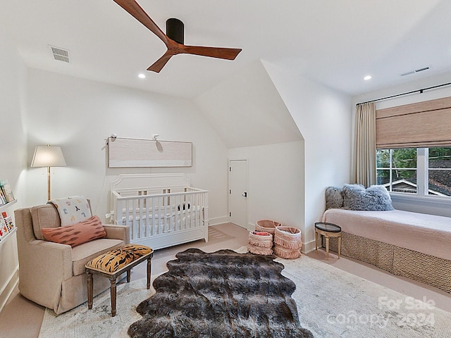 bedroom featuring vaulted ceiling, ceiling fan, and a nursery area