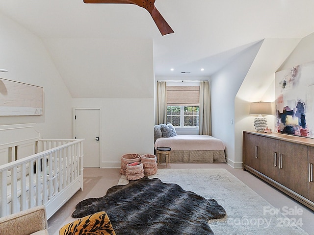 bedroom featuring light colored carpet, lofted ceiling, a nursery area, and ceiling fan