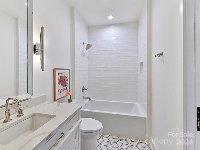 full bathroom featuring toilet, tiled shower / bath, tile patterned floors, and vanity