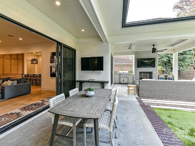 view of patio with exterior kitchen, ceiling fan, a grill, and an outdoor living space