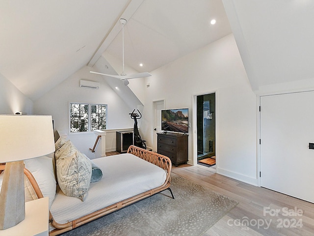 bedroom featuring light wood-type flooring, beam ceiling, high vaulted ceiling, a wall mounted air conditioner, and ensuite bathroom