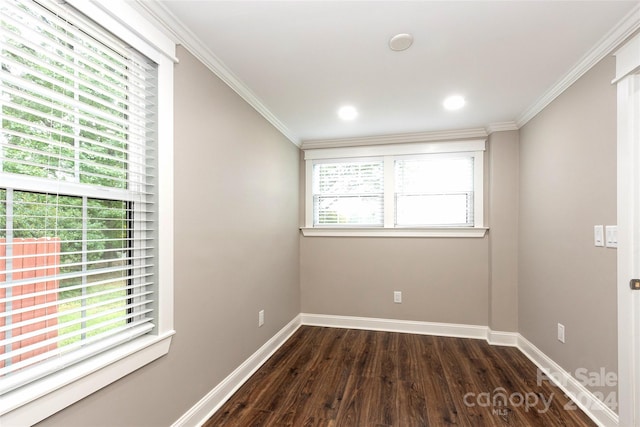 spare room with dark wood-type flooring, a wealth of natural light, and crown molding