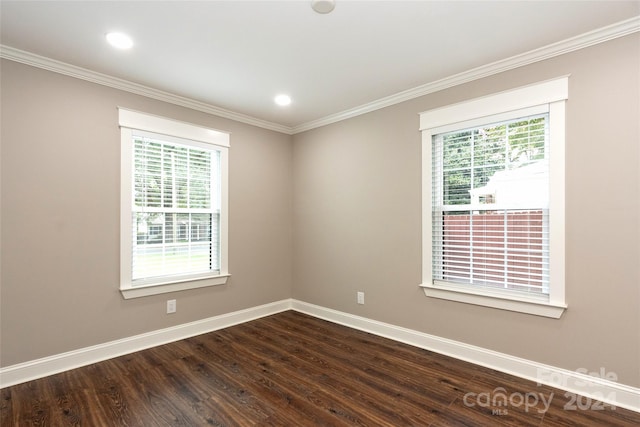 unfurnished room featuring dark wood-type flooring, ornamental molding, and plenty of natural light