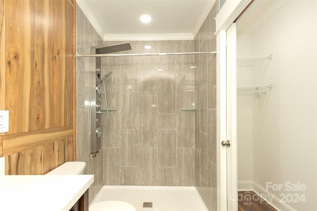 bathroom with tiled shower, toilet, hardwood / wood-style floors, ornamental molding, and vanity