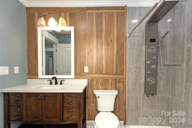 bathroom featuring toilet, vanity, ornamental molding, and a tile shower