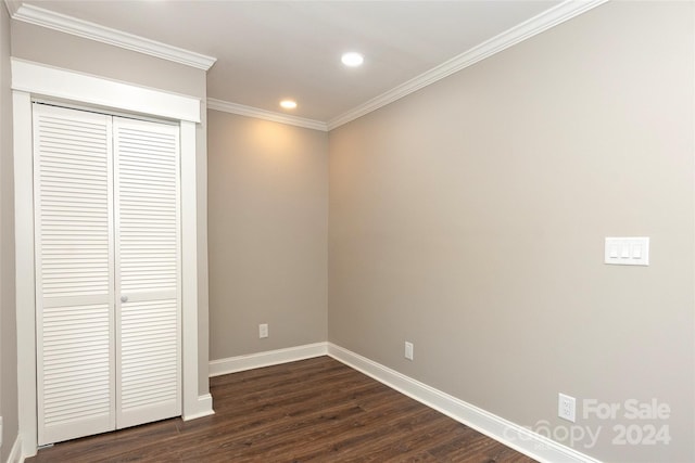 unfurnished bedroom featuring dark wood-type flooring, a closet, and crown molding