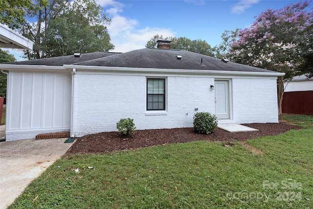 rear view of house featuring a yard