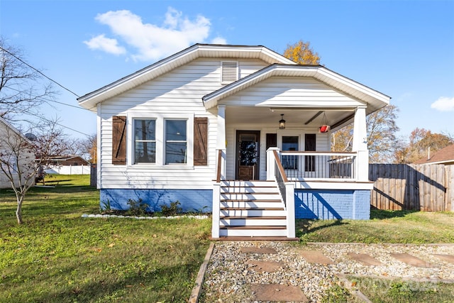 bungalow-style house featuring covered porch and a front yard