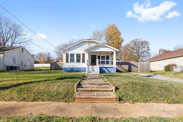 bungalow-style house featuring central AC, a front lawn, and covered porch