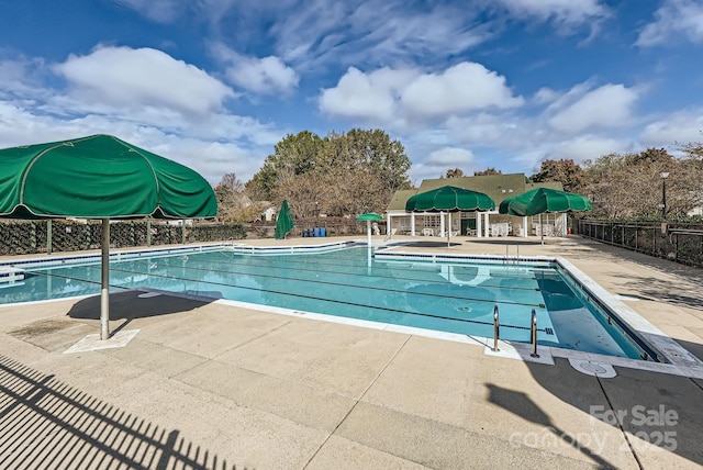 community pool featuring fence and a patio area