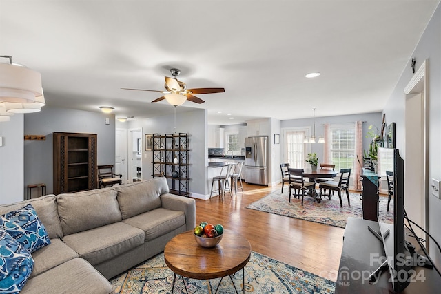 living room featuring ceiling fan, light hardwood / wood-style flooring, and sink