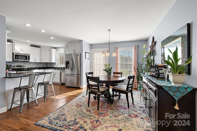 dining space with a chandelier, dark hardwood / wood-style floors, and sink