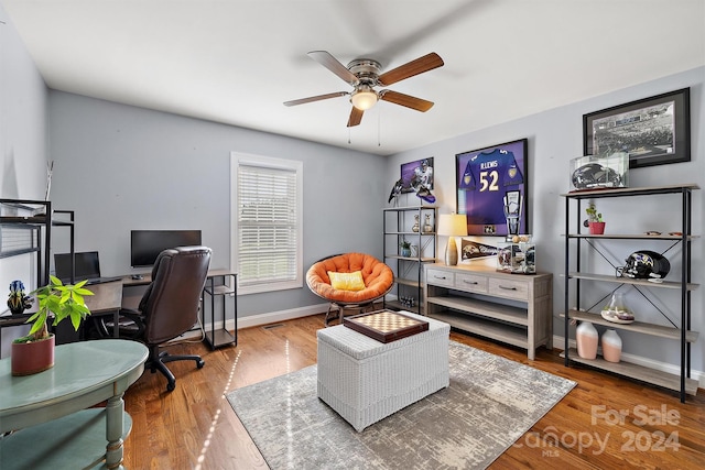 home office with wood-type flooring and ceiling fan