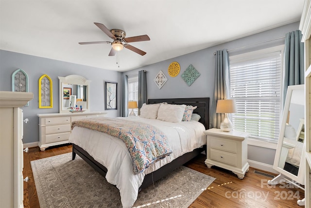 bedroom featuring multiple windows, ceiling fan, and dark hardwood / wood-style floors