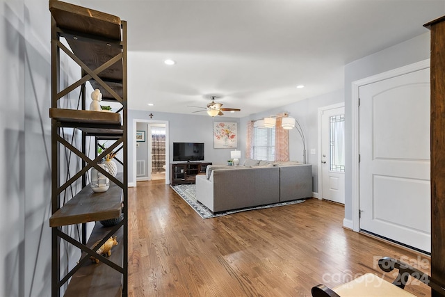 living room featuring ceiling fan and hardwood / wood-style flooring